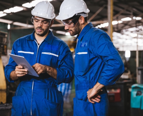 Two workers in the field looking at tablet