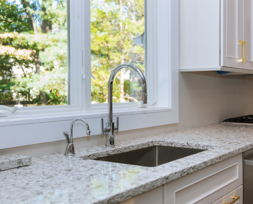 Side view of a sink in clean kitchen, marble countertops