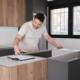 man using measuring tape before placing countertops on modern kitchen